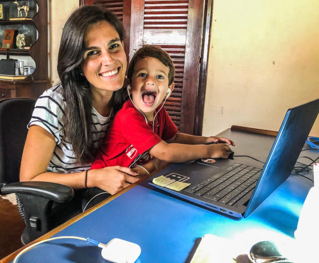 Fernanda Agile Expert na K21 com o seu filho ao colo mexendo no laptop.